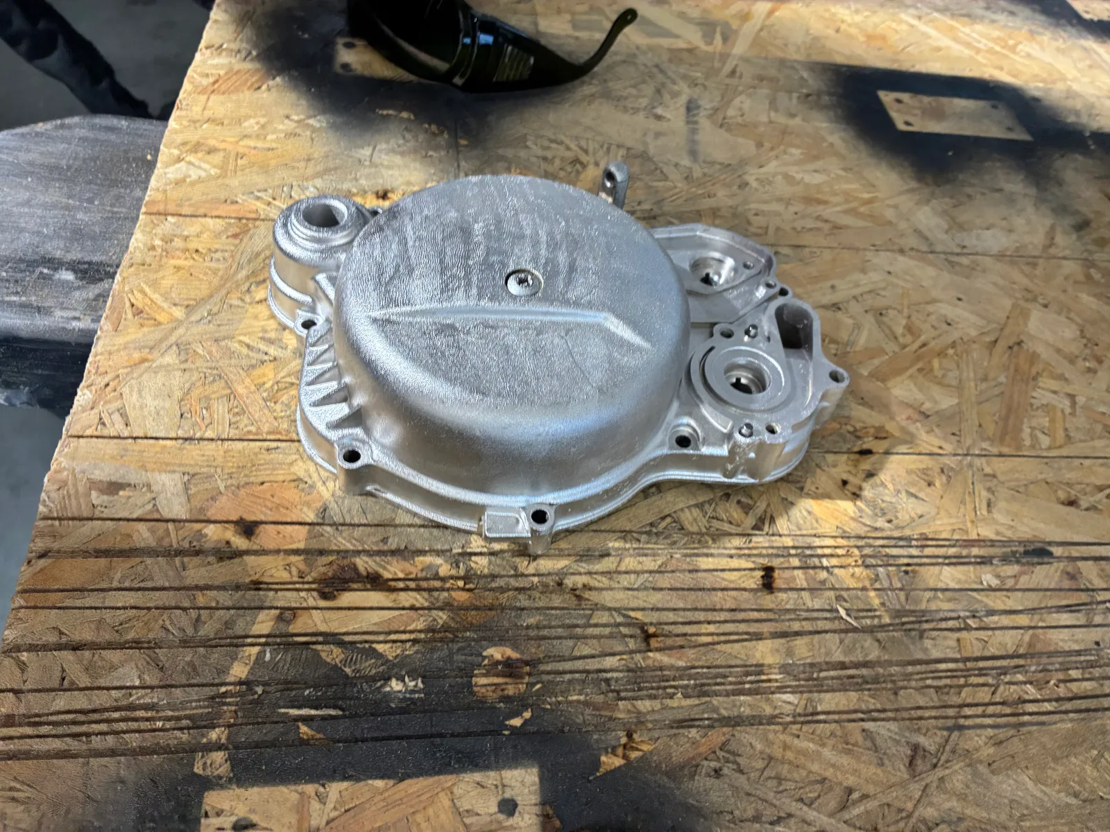 Aluminiowa pokrywa silnika motocyklowego po czyszczeniu laserowym, na warsztatowym blacie