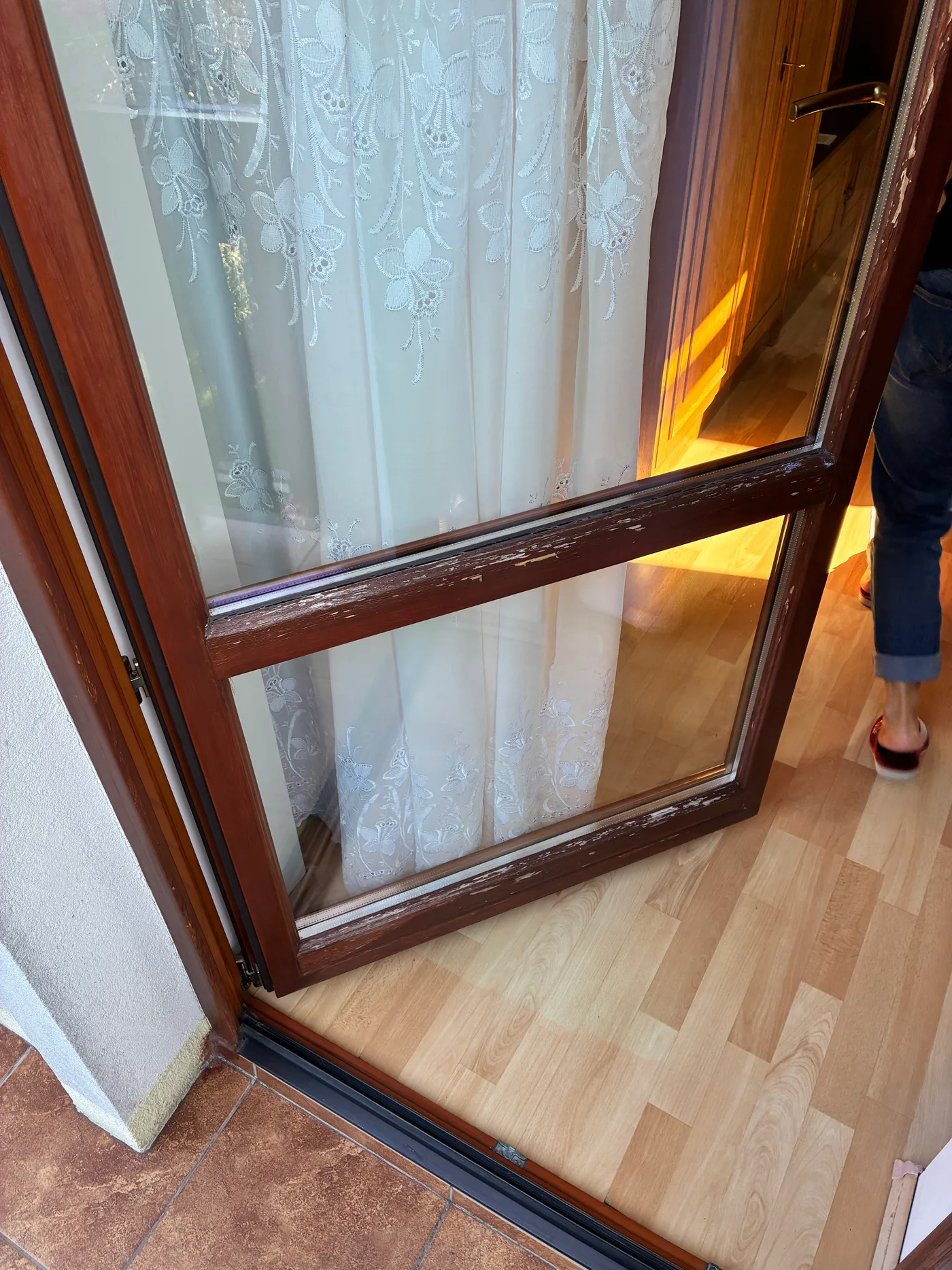 Skrzydło drzwi balkonowych ze starą lazurą schodzącą płatami